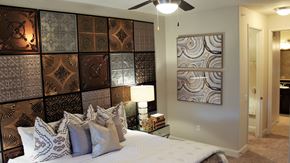 Houston apartment for rent - a bedroom with a bed and a wall of canvases