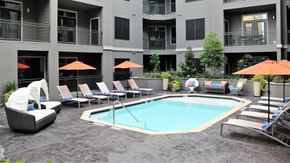 Houston apartment for rent - a swimming pool in a courtyard with chairs and umbrellas