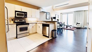 Ottawa apartment for rent - A kitchen with white cabinets and a black stove top oven.