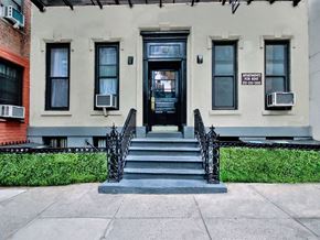 New York apartment for rent - the front of a white building with stairs and a black wrought iron fence