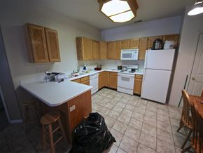 Provo condo for rent - a kitchen with white appliances and wooden cabinets