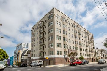 San Francisco apartment for rent - A large beige building with many windows and a fire escape on the side.