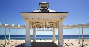 Long Branch apartment for rent - A gazebo with a clock on the front is situated on a beach.