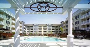 Long Branch apartment for rent - A pool area with a white pergola and a logo on it.