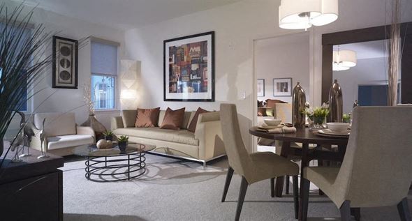Long Branch apartment for rent - A modern living room with a white couch, a coffee table, and a dining table with chairs.
