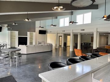 Mission townhouse for rent - A modern open space with a white couch, grey tables, and a grey floor.