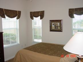 Houston apartment for rent - a bedroom with a bed and three windows