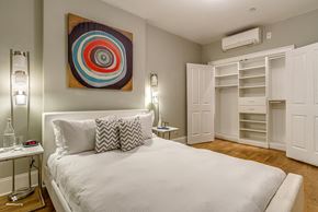 Brooklyn apartment for rent - A bedroom with a large bed and a colorful artwork on the wall.