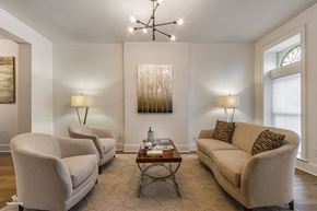 Brooklyn apartment for rent - A living room with a couch, two chairs, a coffee table, and a chandelier.