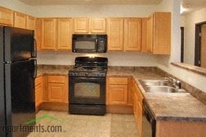 West Des Moines apartment for rent - a kitchen with wooden cabinets and black appliances