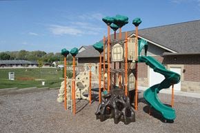 Des Moines apartment for rent - A playground with a green slide and orange poles.