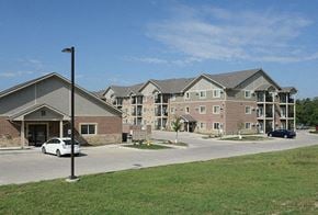 Des Moines apartment for rent - A white car is parked in front of a building with a sign that says B on it.