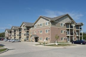 Des Moines apartment for rent - A large apartment complex with multiple buildings and cars parked in the lot.