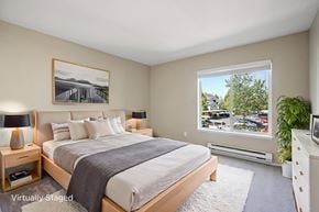 Hillsboro apartment for rent - A bedroom with a large bed and a window overlooking a parking lot.