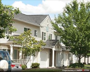 Hillsboro apartment for rent - A white house with a blue car parked in front.