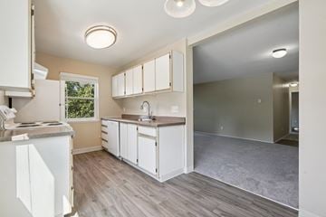 Hillsboro apartment for rent - A kitchen with white cabinets and a grey floor.