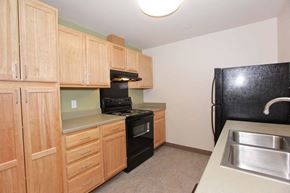 Pittsburgh apartment for rent - a kitchen with black appliances and wooden cabinets