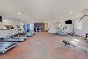 Glen Burnie townhouse for rent - a gym with treadmills and other exercise equipment in a room with a window