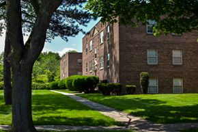 Rochester townhouse for rent - a brick building with green grass and trees and a sidewalk