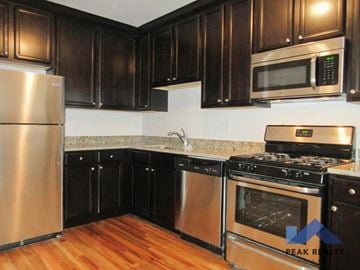 Chicago apartment for rent - a kitchen with stainless steel appliances and black cabinets