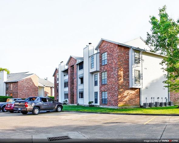 Kenner apartment for rent - an apartment building with cars parked in a parking lot