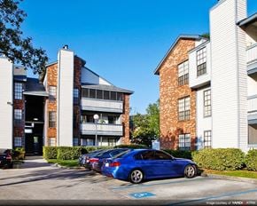 Kenner apartment for rent - a blue car parked in a parking lot in front of an apartment building