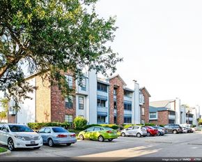 Kenner apartment for rent - a city street with cars parked in front of apartment buildings