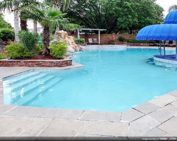 New Orleans apartment for rent - a swimming pool with a blue umbrella next to it