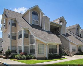 Gretna apartment for rent - a tan house with a roof and a sidewalk