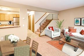 Minnetonka apartment for rent - brightly lit living room with dining table, coffee table, white couch with red pillows
