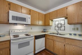Shakopee apartment for rent - a kitchen with white appliances and wooden cabinets