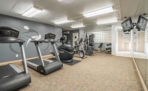 St. Paul apartment for rent - a gym with cardio equipment and weights in a building