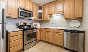 St. Paul apartment for rent - a kitchen with stainless steel appliances and wooden cabinets