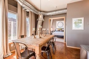 Minneapolis apartment for rent - wooden dining room table with metal chairs and an open doorway to the bedroom in the background