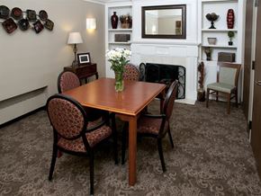 St. Paul apartment for rent - Wooden table surrounded by chairs, a vase in the center, next to a fireplace and a shelf