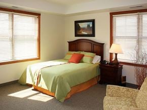 St. Paul apartment for rent - a bedroom with a bed and a chair and two windows