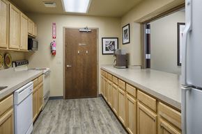 St. Paul apartment for rent - Community kitchen with light wooden cupboards and a galley layout. A stove, oven, and microwave on the left, a refrigerator on the right