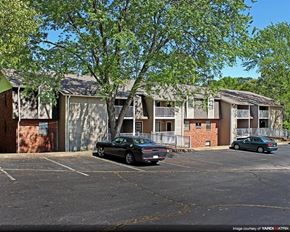 Greenville apartment for rent - an apartment building with cars parked in a parking lot