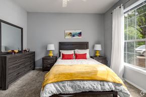 Charlotte apartment for rent - a bedroom with a bed and a large window