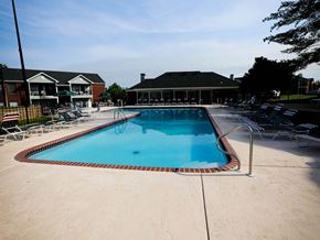 St. Charles apartment for rent - a swimming pool with chairs around it in front of a building