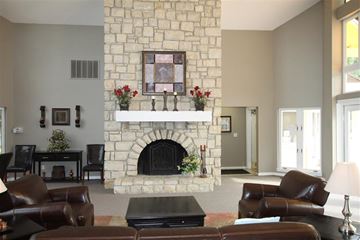 Kansas City apartment for rent - a living room with a stone fireplace and leather furniture