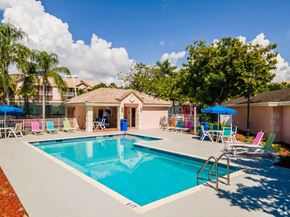 Hallandale Beach apartment for rent - a swimming pool with chairs around it and a house