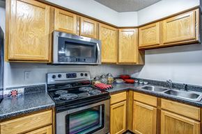 Chesterfield townhouse for rent - a kitchen with stainless steel appliances and wooden cabinets