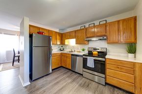 Manchester townhouse for rent - a kitchen with stainless steel appliances and wooden cabinets