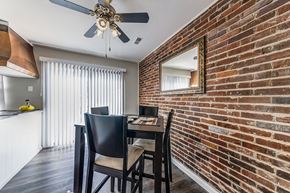 St. Louis townhouse for rent - an exposed brick wall in a dining room with a table and chairs