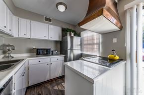 St. Louis townhouse for rent - a kitchen with white cabinets and stainless steel appliances