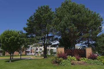 Chanhassen apartment for rent - a sign for the centennial hill apartments is shown in front of trees
