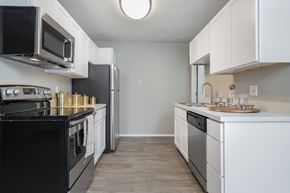 Farmington Hills apartment for rent - a kitchen with white cabinets and black appliances