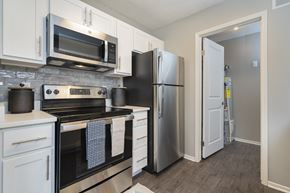 Westlake apartment for rent - a kitchen with stainless steel appliances and white cabinets