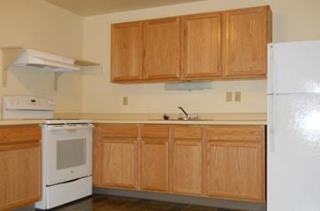Burlington apartment for rent - a kitchen with white appliances and wooden cabinets